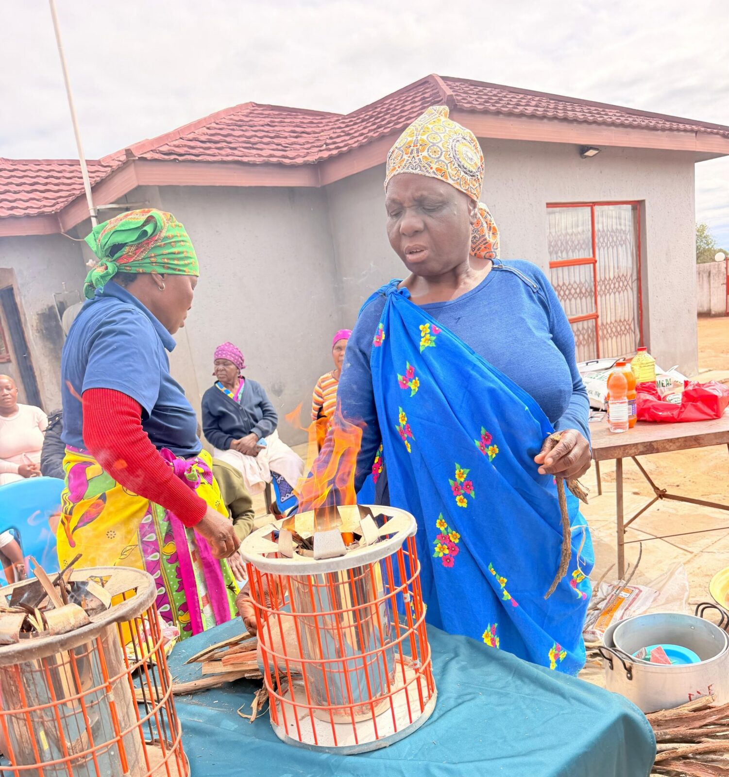 Confident stove users demonstrate their use during a community meeting